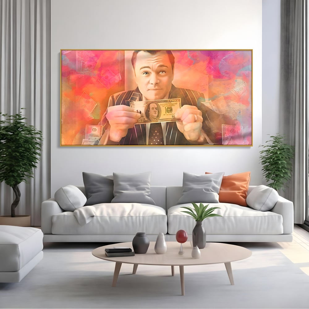 Tablou canvas cu tablou cu actorul leonardo dicaprio tinand bani, in rama de aluminiu auriu, pe perete intr-un living